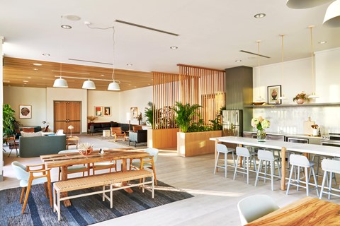 a living room and dining room with tables and chairs and a kitchen